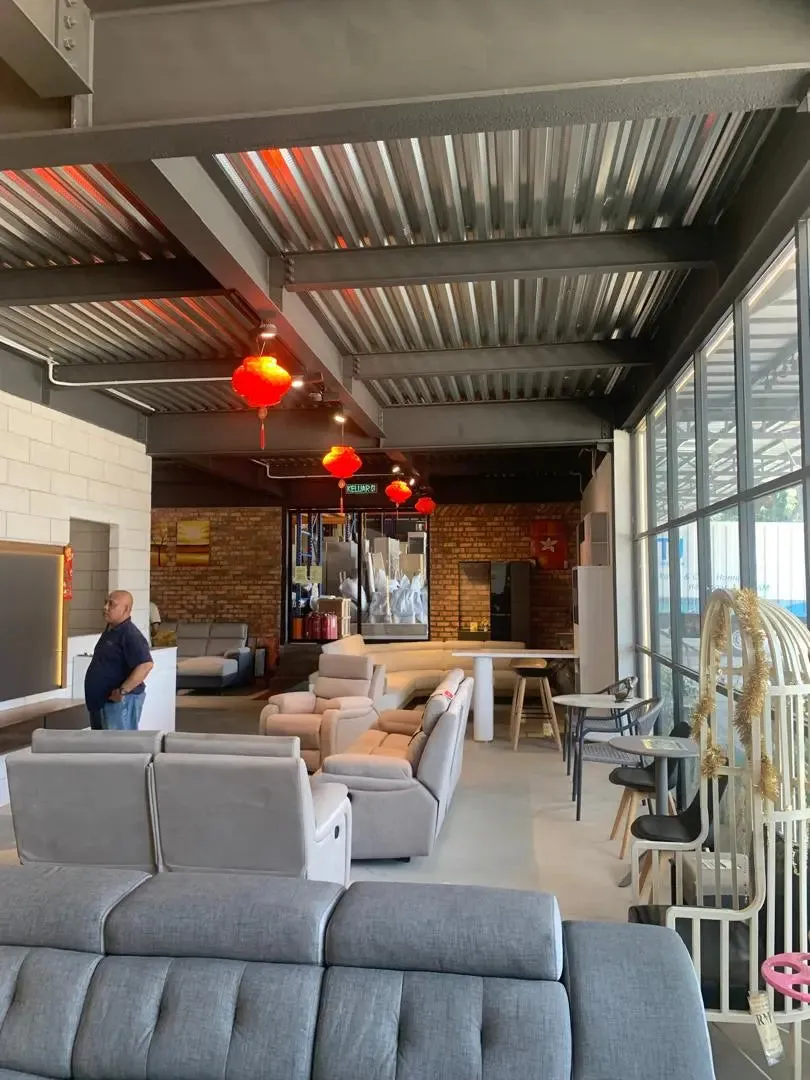 Modern living room with gray sofas, a brick wall, and decorative elements.